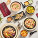 A table with Acopa Ugoki melamine plates of food and chopsticks.