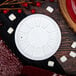 A white plastic Dart lid on a table with a red plate and marshmallows.