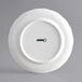 An Acopa Condesa white porcelain plate with scalloped edges and a wide rim.