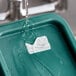 A green container with a water droplet on it being filled with water.