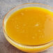 A bowl of passion fruit puree on a counter in a juice bar.