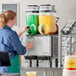 A woman pouring a green liquid into a Narvon granita machine.