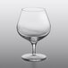 A close up of a Luigi Bormioli Napoleon Cognac Glass with a curved rim and a stem.