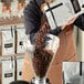 A person pouring Arrosto Ethiopia Yirgacheffe coffee beans into a glass container.