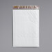 A white plastic bag with a Lavex Self-Sealing Polyethylene Bubble Mailer inside.
