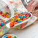 A person using a Choice stainless steel bar scoop to serve candy from a jar.