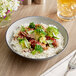 A matte grey and black melamine bowl filled with rice and broccoli on a table.