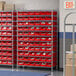 A Regency wire shelving unit with red storage bins.