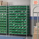 A Regency wire shelving unit with green bins on the shelves.