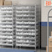 A Regency metal wire shelving unit with clear plastic bins on shelves.