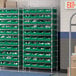 A Regency wire shelving unit with green bins on shelves.