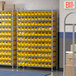 A Regency wire shelving unit with yellow bins on every shelf.