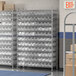 A metal Regency wire shelving unit with plastic bins on each shelf.