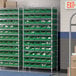A green Regency wire shelving unit with green bins on white shelves.