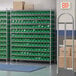 A Regency wire shelving unit with green bins on shelves.
