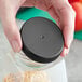 A hand holding a jar with a black 63/400 unlined ribbed plastic cap.