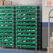 A Regency wire shelving unit with green bins on the shelves.