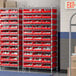 A Regency wire shelving unit with red bins on shelves.
