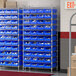 A Regency wire shelving unit with blue bins on the shelves.