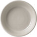 A white stoneware olive/tapas dish with a circular spiral pattern on it.