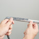 A close-up of hands holding a Unger ErgoTec squeegee blade