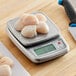 An AvaWeigh Platinum stainless steel digital portion scale with raw chicken and scallops on it.