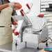 A man in an apron using a Berkel meat slicer to cut meat on a table.