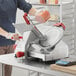 A man using a Berkel medium-duty manual meat slicer to slice meat.