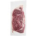 A Rastelli's Black Angus New York Strip steak in a plastic package on a white surface.