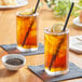 Two glasses of Tractor Beverage Co. Organic Unsweet Tea with lemon slices and straws.