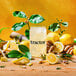 A glass of Tractor Beverage Co. Organic Lemonade with a lemon wedge on the rim.