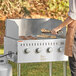 A person using a Backyard Pro Wind Guard to cook on a grill.