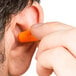 A person using a Cordova cordless orange earplug.