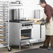 A man wearing a chef's outfit putting cookies into a Main Street Equipment natural gas range.