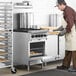 A man wearing a chef's outfit using a Main Street Equipment commercial gas range to bake cookies.