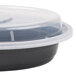 A black plastic Pactiv Newspring VERSAtainer oval container with a clear lid.