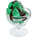 A green ice cream with chocolate syrup in a Libbey glass bowl.