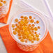 A glass of milk with Fanale Mango Popping Boba floating in it.