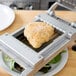 A piece of chicken on a Nemco Easy Chicken Slicer.