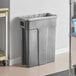 A dark cool gray Toter Slimline 23 gallon plastic trash can with a plastic bag on the side.