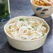 A GET Japanese Traditional scalloped edge melamine bowl filled with noodles in soup.