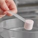 A person holding a Polypropylene Scoop with white powder in it.