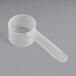 A white plastic measuring scoop with a long handle.