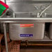 A sink with Noble Products Wash, Rinse, Sanitize, and Water Level labels above it.