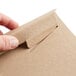 a person opening a brown envelope