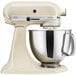 A KitchenAid almond cream tilt head stand mixer with a bowl.