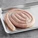 A raw Shaffer Venison Farms fresh water buffalo sausage on a tray.
