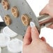 A person's hand using a white gasket to remove a metal part from a Bar Maid A-200 glass washer.