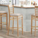 A Lancaster Table & Seating light gray vinyl seat for a wooden chair.