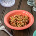 A bowl of rice with vegetables and spices in a Rio orange melamine bowl.